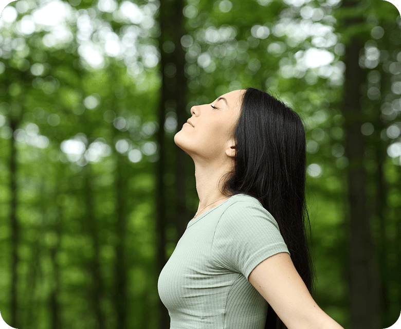 side view portrait Asian woman breathing in the woods