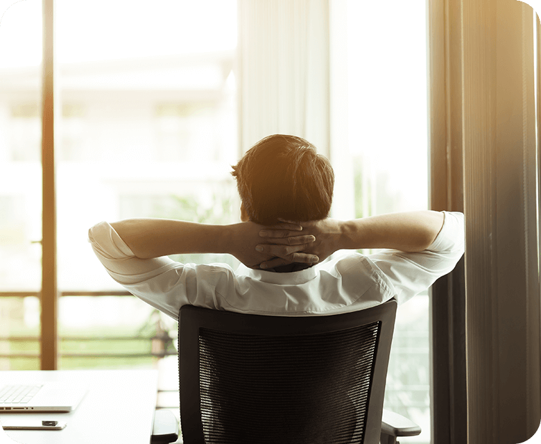 young businessman relaxing sitting in a chair with hands behind his neck