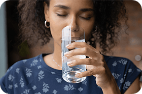 Kvinna sköljer ner Alvedon med vatten