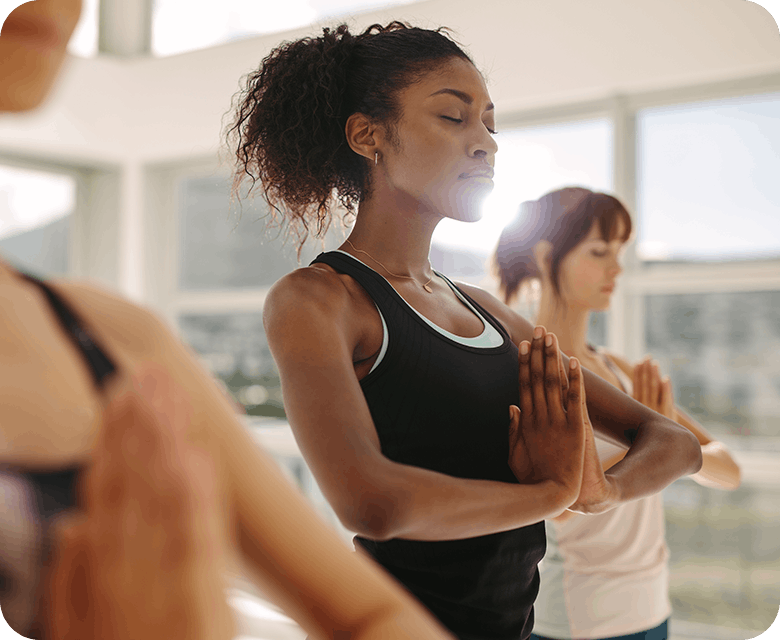 Tre kvinnor övar yoga i studio
