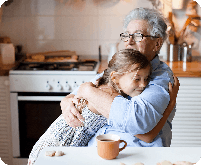 Äldre kvinna kramar om barnbarn