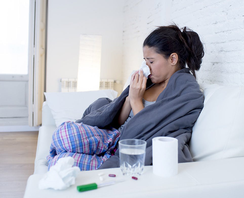 A woman coughing and suffering from body aches A woman coughing and suffering from body aches