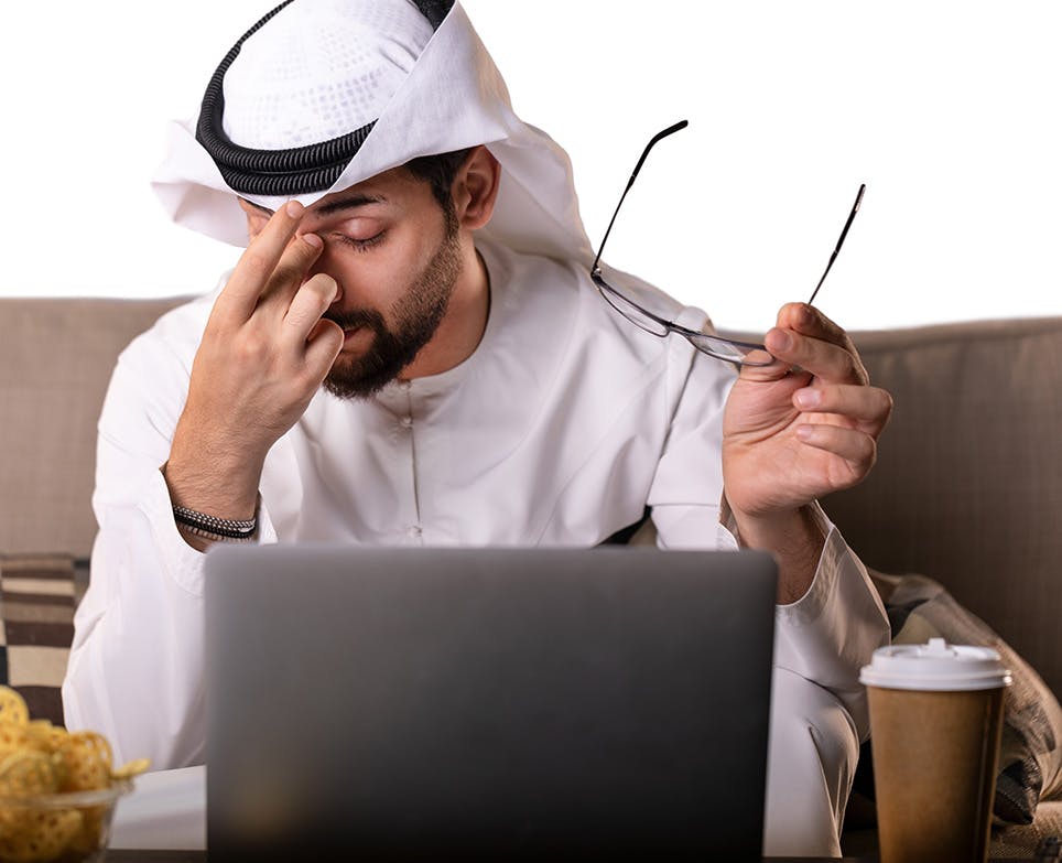 A man removes his glasses due to his headache A man removes his glasses due to his headache