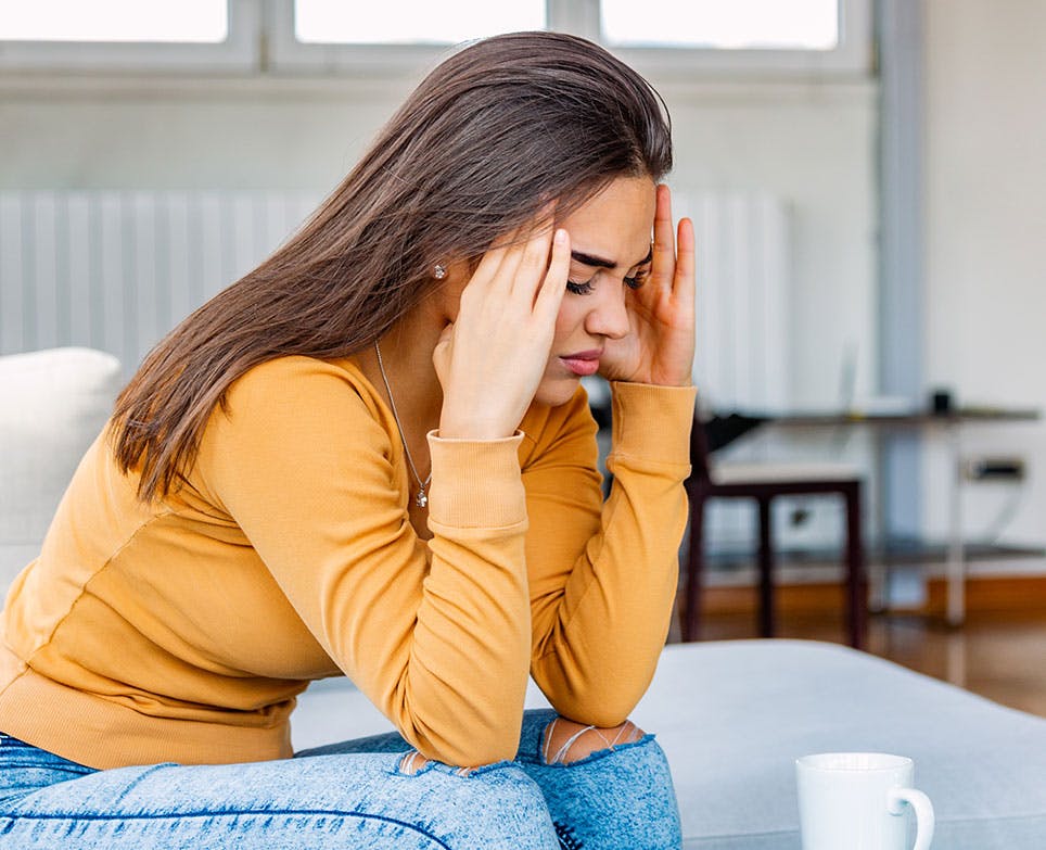 A woman at home dealing with a headache A woman at home dealing with a headache