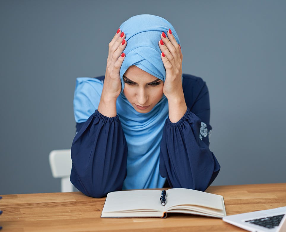 A woman reading and dealing with a headache