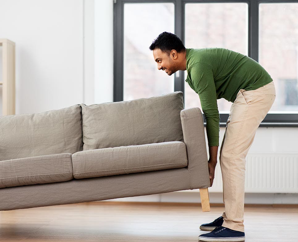 A man lifting a couch A man lifting a couch