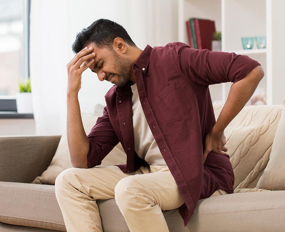 A man dealing with lower back pain A man dealing with lower back pain