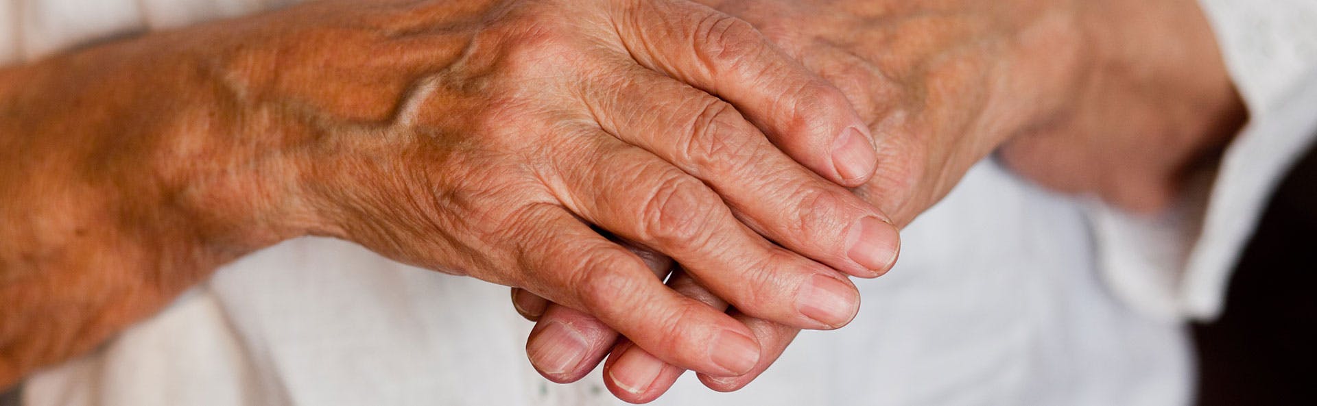 An old woman's right hand holding her left hand An old woman's right hand holding her left hand