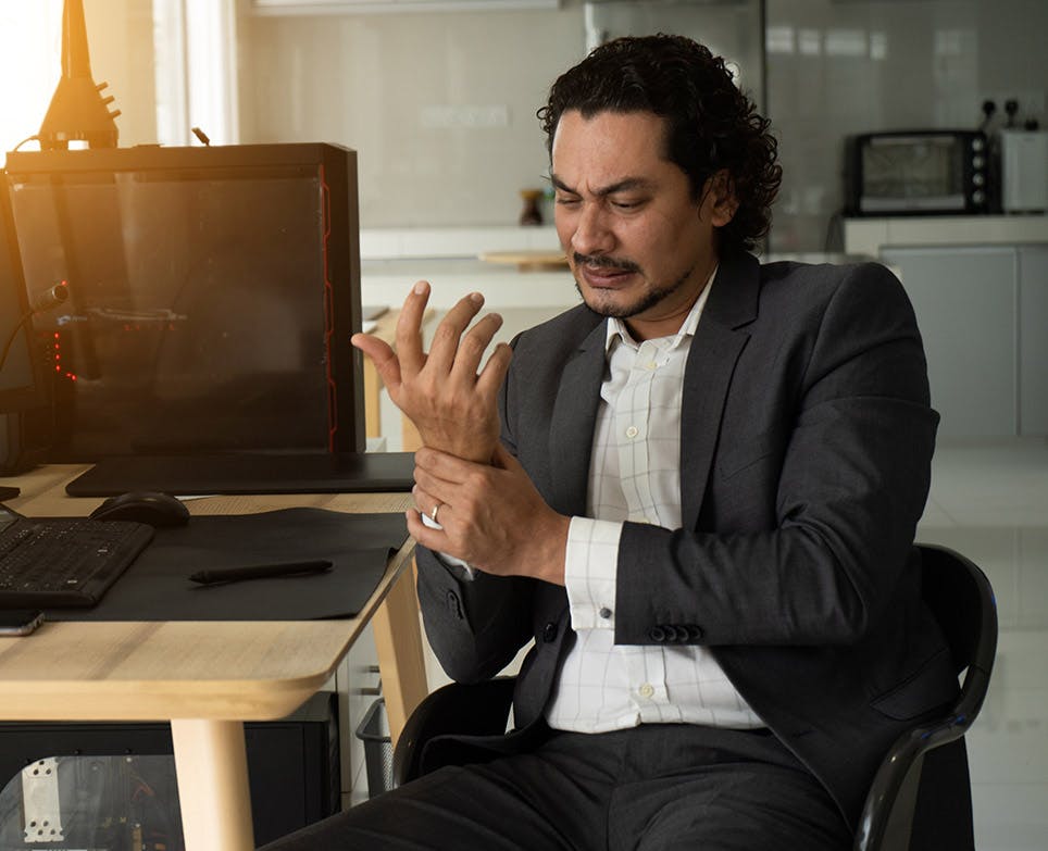 A man dealing with pain in his right hand A man dealing with pain in his right hand