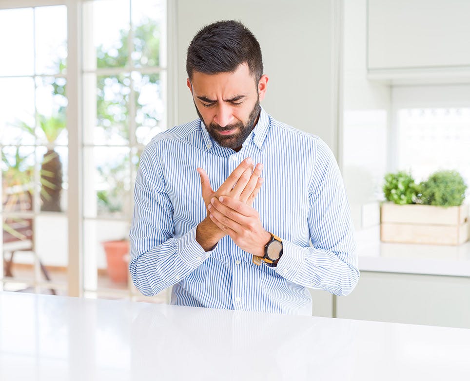 A man experiencing bone pain in his hand A man experiencing bone pain in his hand