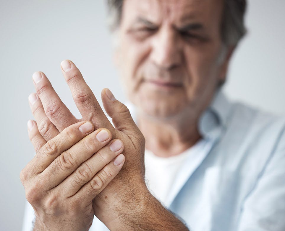 A man handling pain in his left hand A man handling pain in his left hand