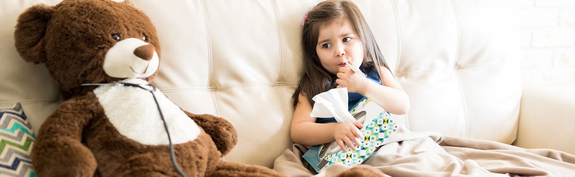 A sick child sitting next to a teddy bear A sick child sitting next to a teddy bear