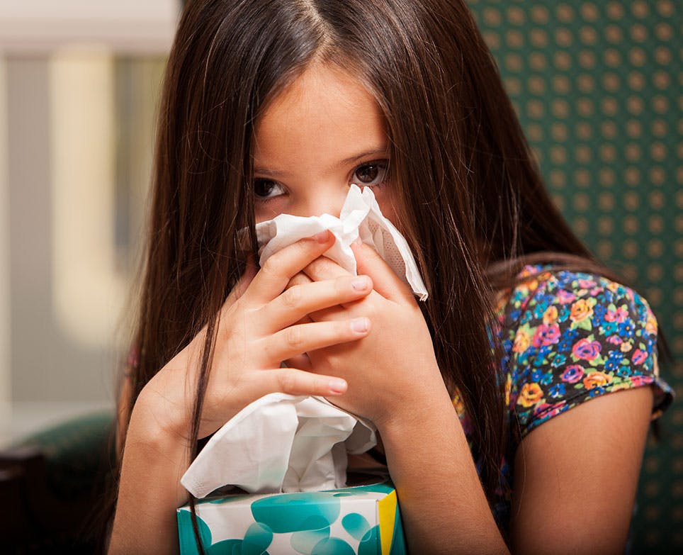 A girl suffering from a cold and a fever A girl suffering from a cold and a fever