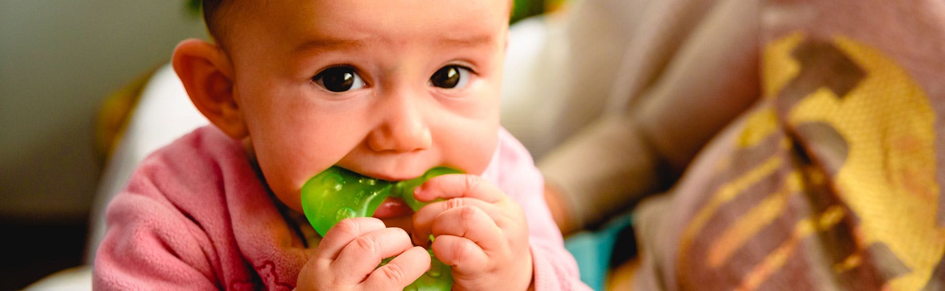 A baby using a teether A baby using a teether
