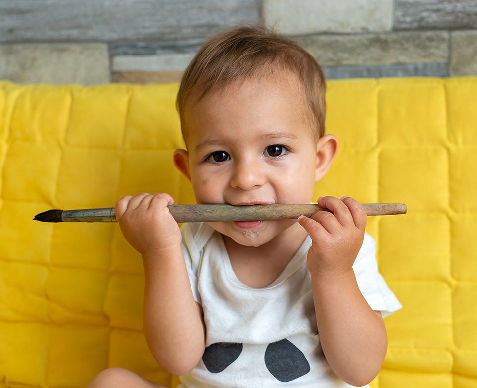 A baby chewing a brush