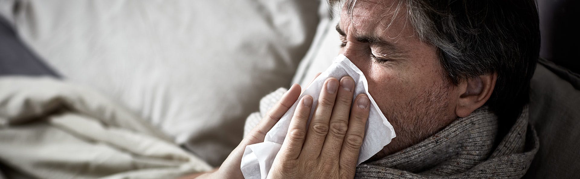 Man with nasal congestion blowing his nose. 