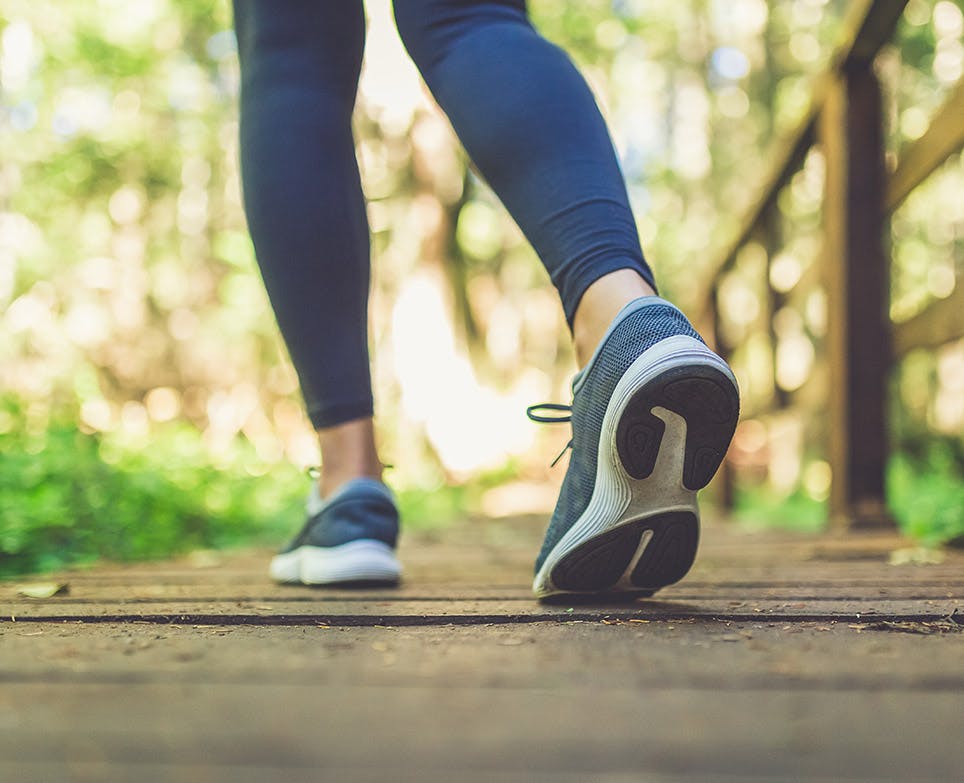 Legs of a sportswoman walking outdoors. 