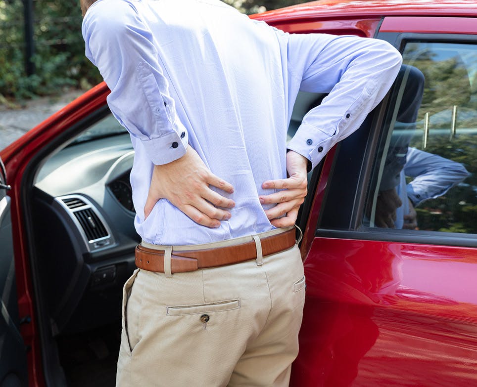 Man in pain, holds his lower back. 