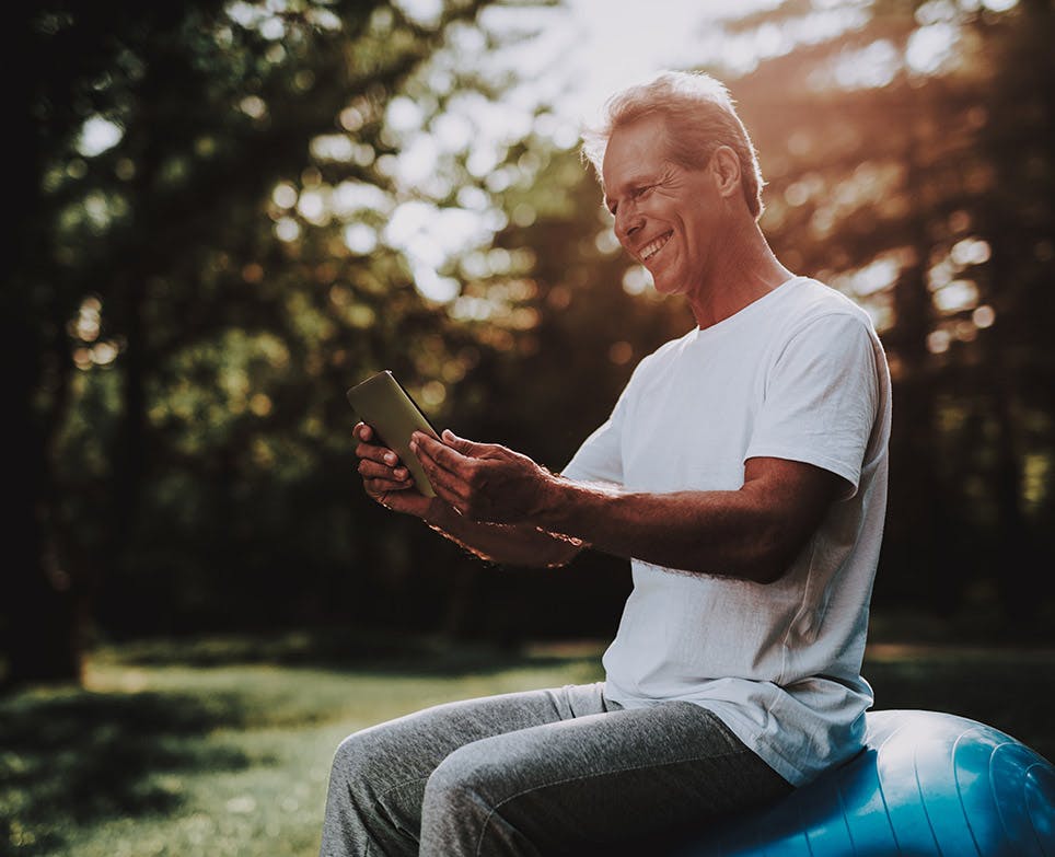 Older man checking his mobile while he enjoys working out. 