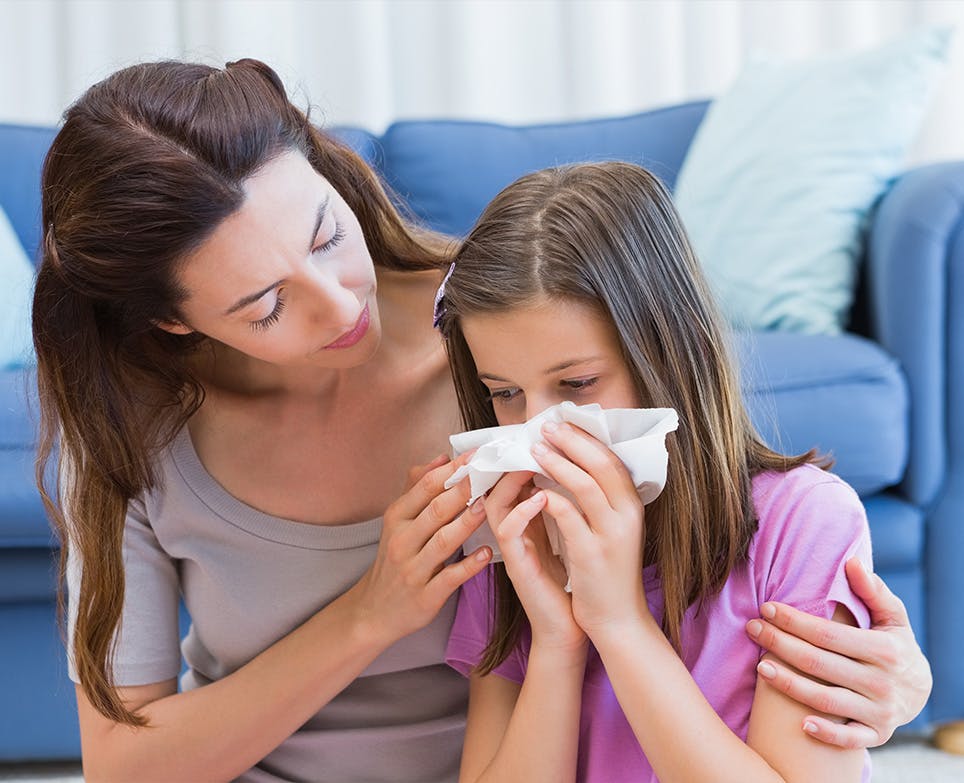 Mother taking care of her daughter, who has flu-like symptoms. 