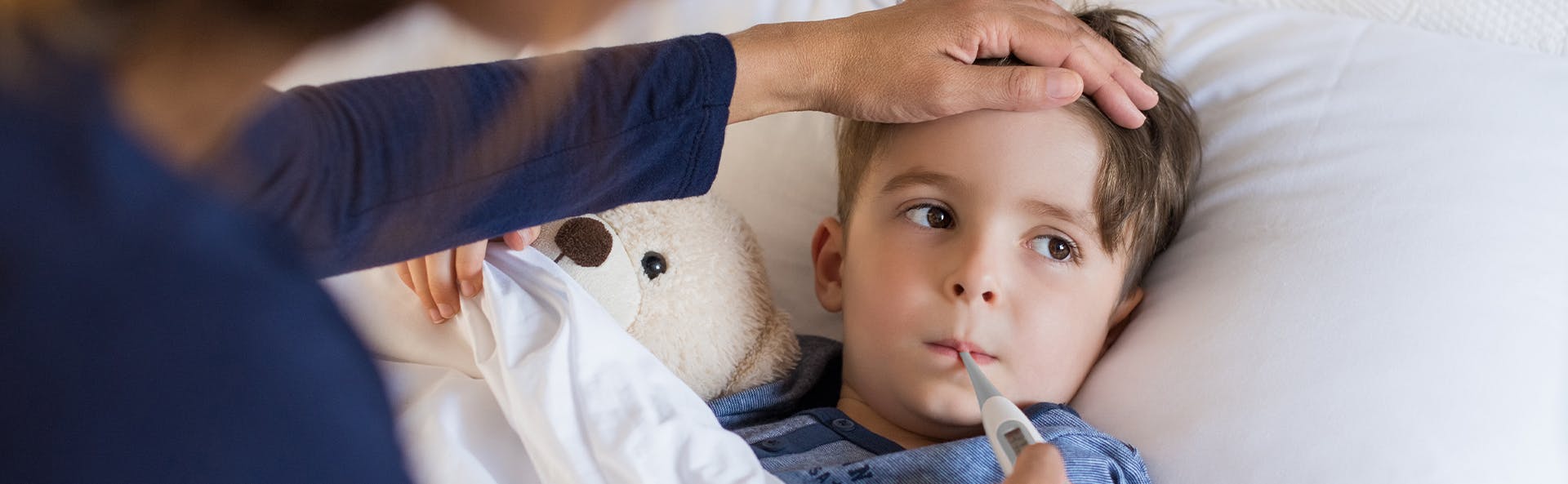 Mother taking her child's temperature using a digital thermometer. 