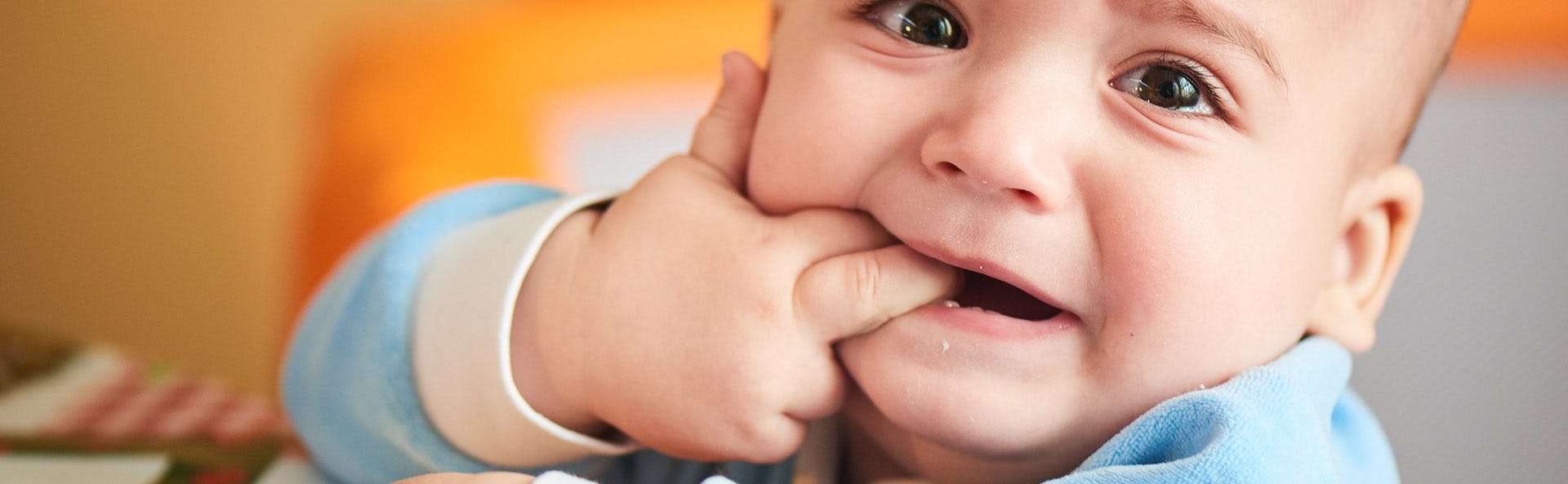 Baby with his fingers in his mouth. 