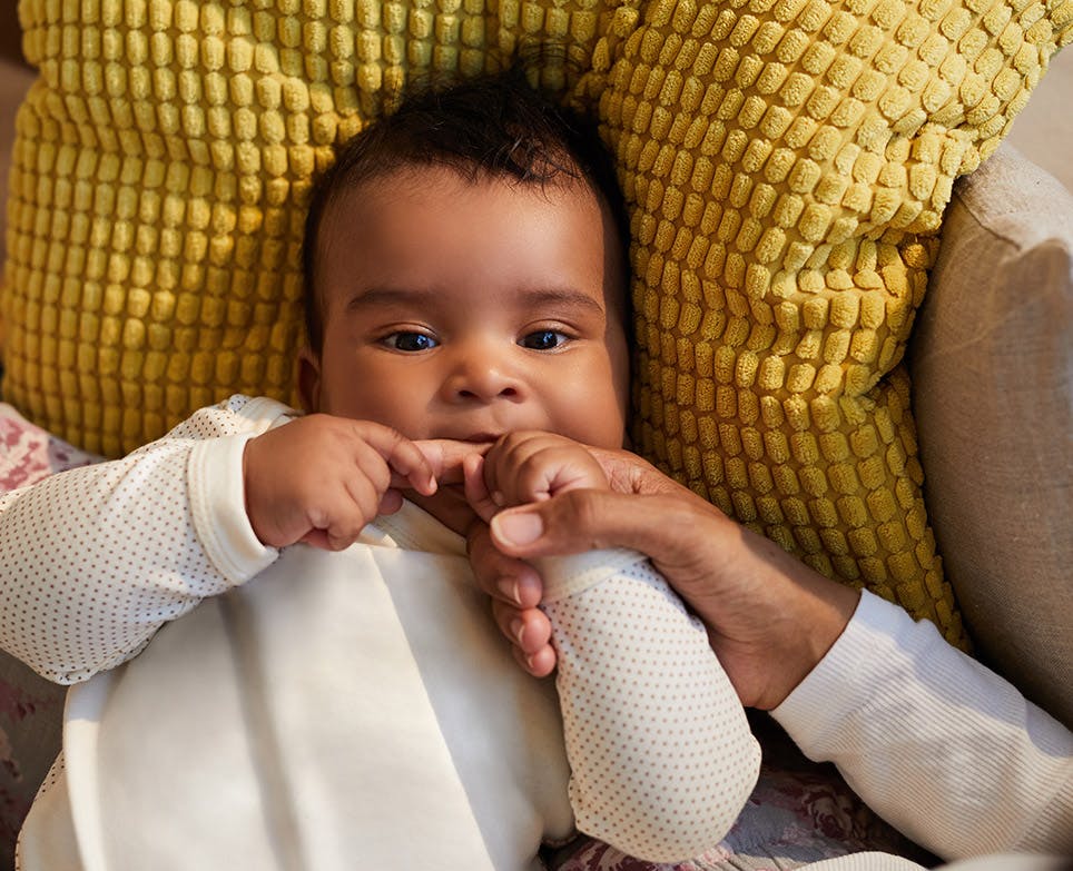 Baby sucking his father's finger. 