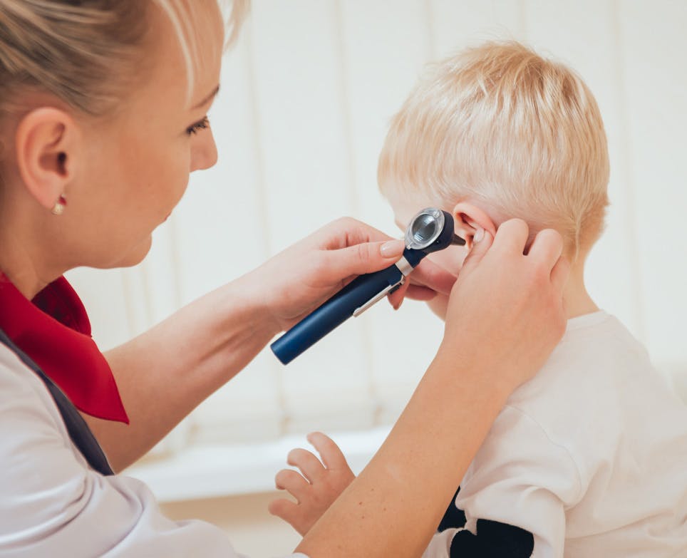 Doctor checking baby's ear