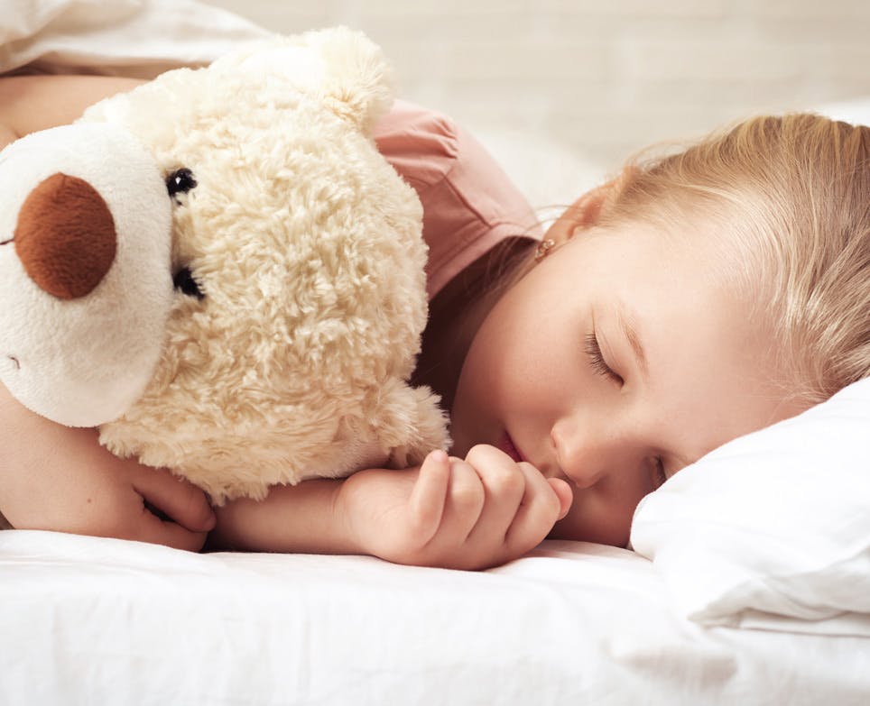 Girl sleeping with her teddy