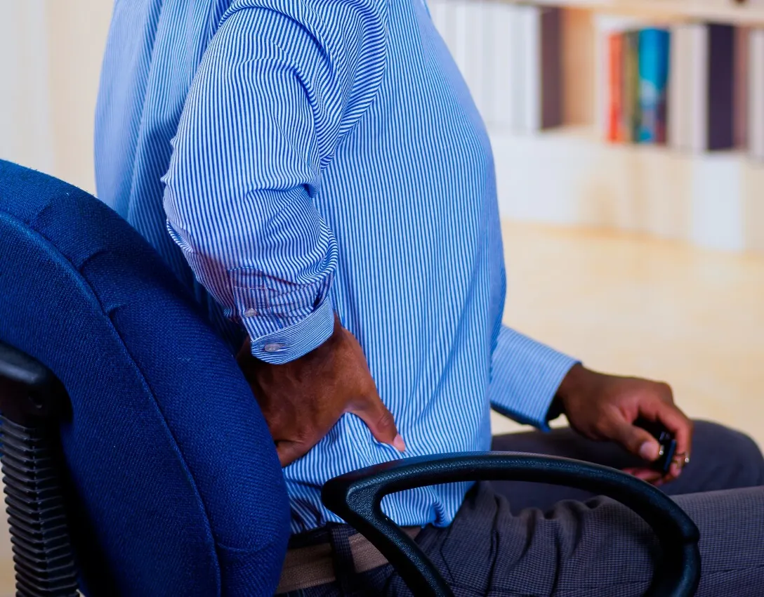 Person holding lower back experiencing backpain
