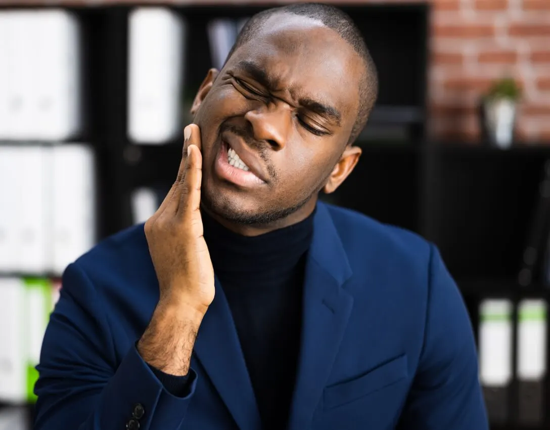 Man holding jaw experiencing toothache pain