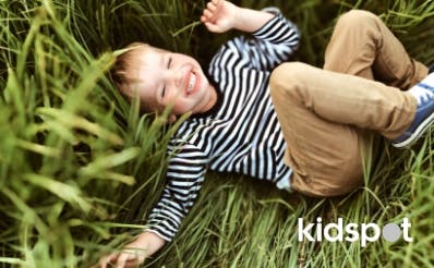Boy giggling lying in grass