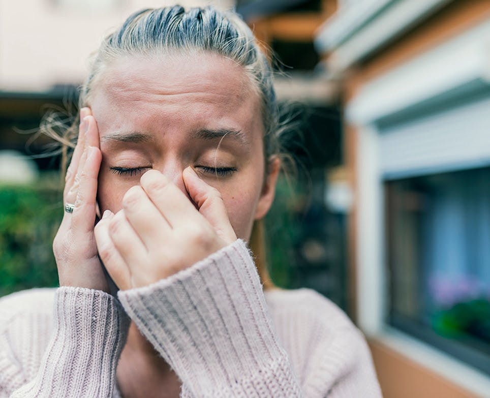 Mujer joven con dolor en la nariz y la cabeza. 