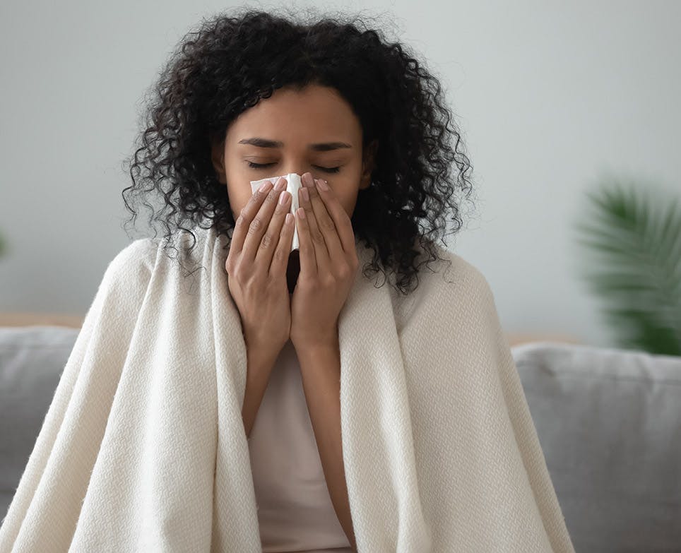 Mujer con congestión nasal limpiando su nariz. 