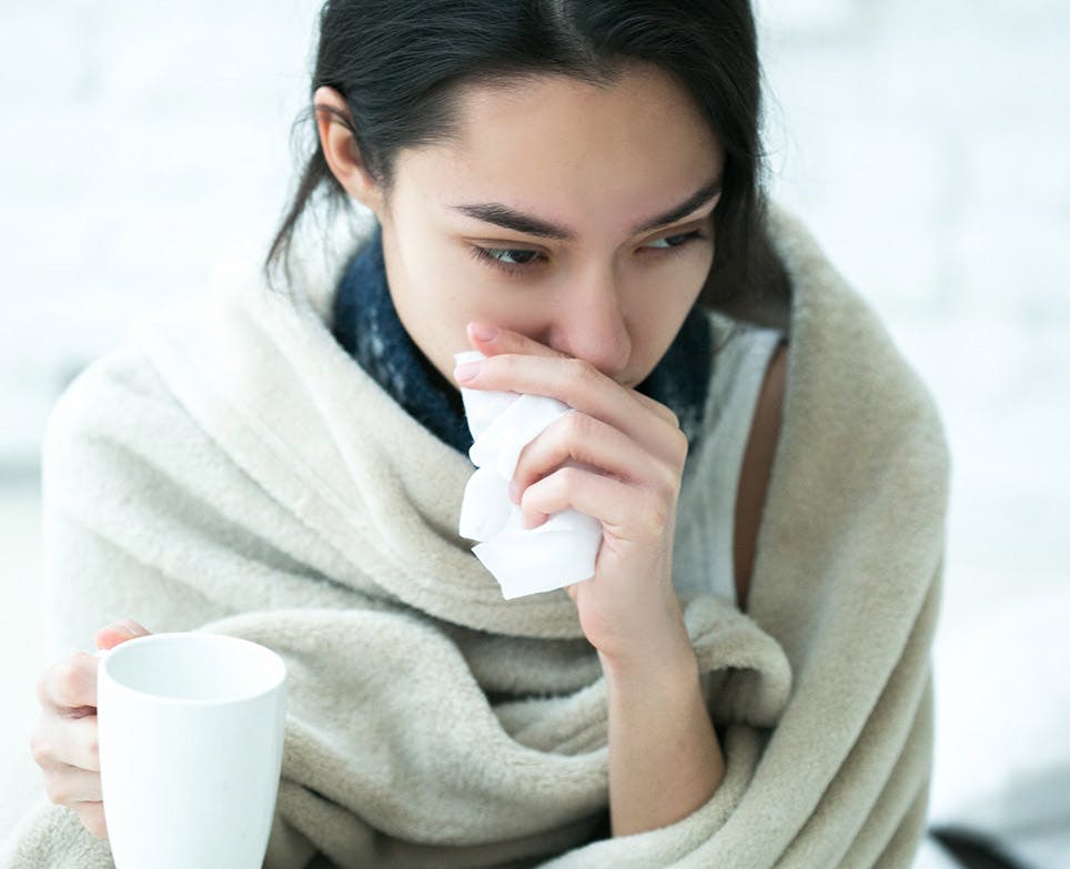 Mujer con congestión nasal limpiando su nariz. 