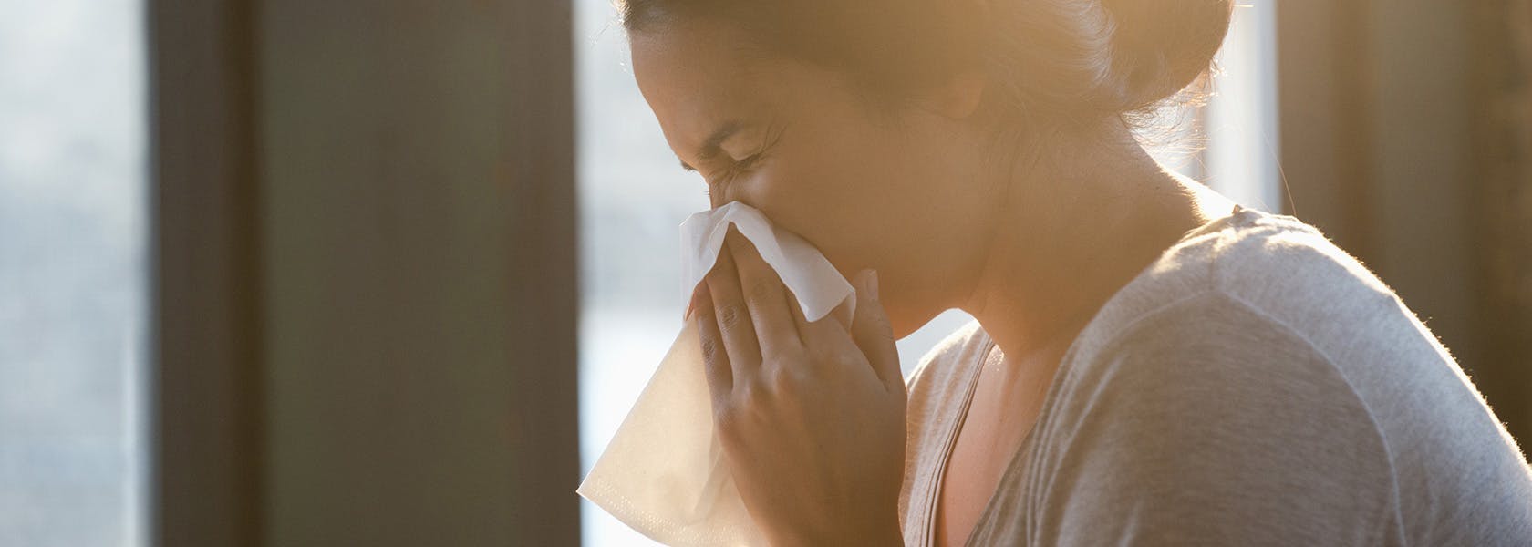 Mujer con congestión nasal limpiando su nariz.