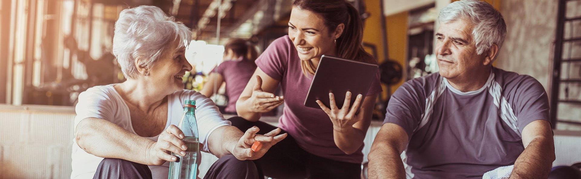 Pareja de adultos mayores conversan con su entrenadora. Pareja de adultos mayores conversan con su entrenadora.