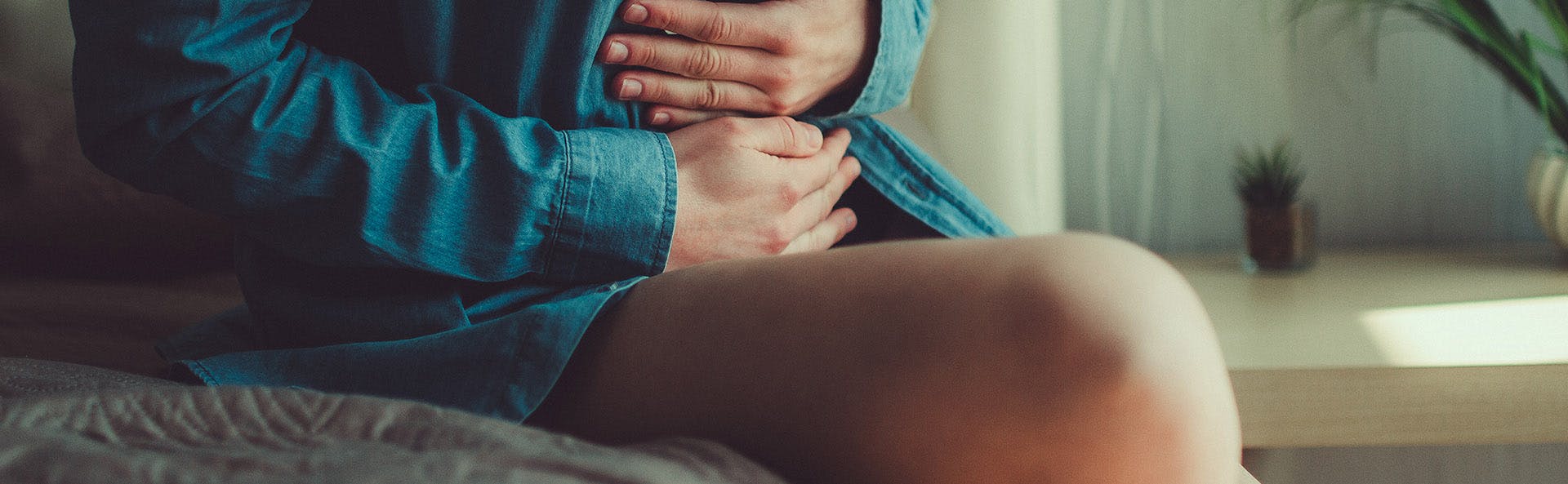 Mujer tocando su abdomen bajo en señal de dolor. Mujer tocando su abdomen bajo en señal de dolor.