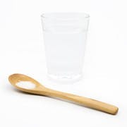 Un vaso de vidrio y una cuchara de madera. 