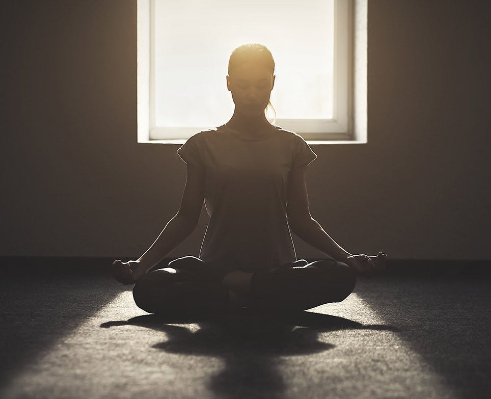 Mujer practicando poses de yoga en interiores