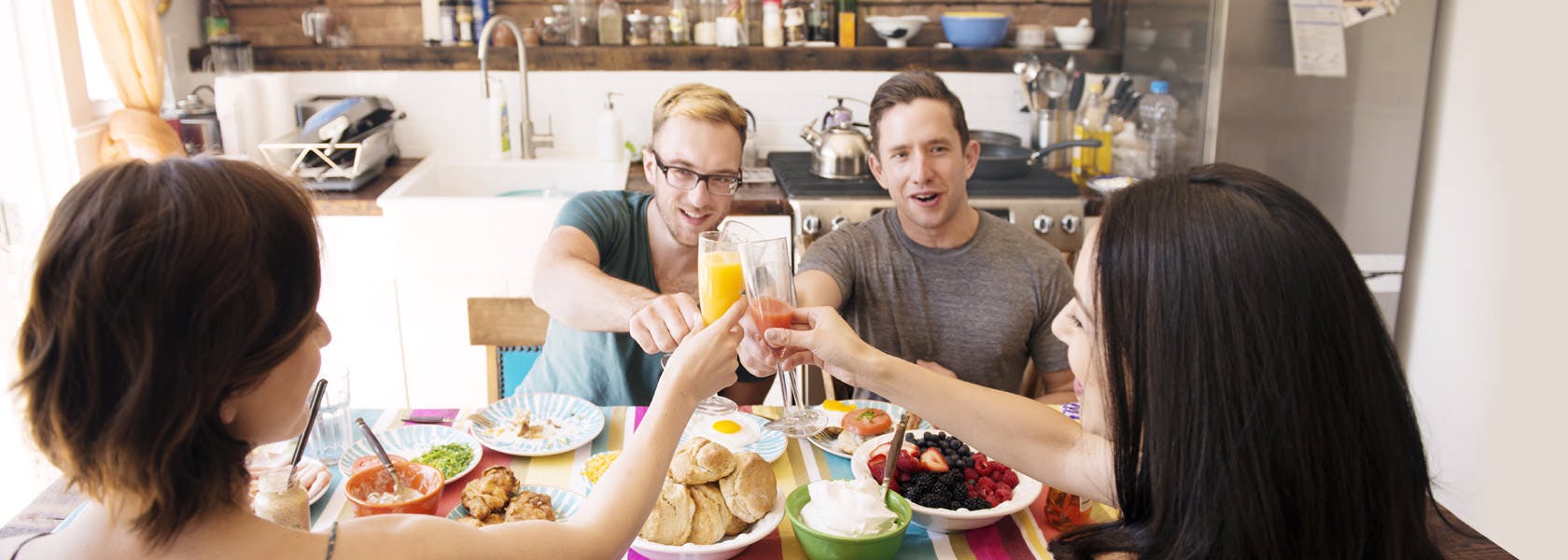 Friends Raise Their Glasses Together In A Toast At Breakfast
