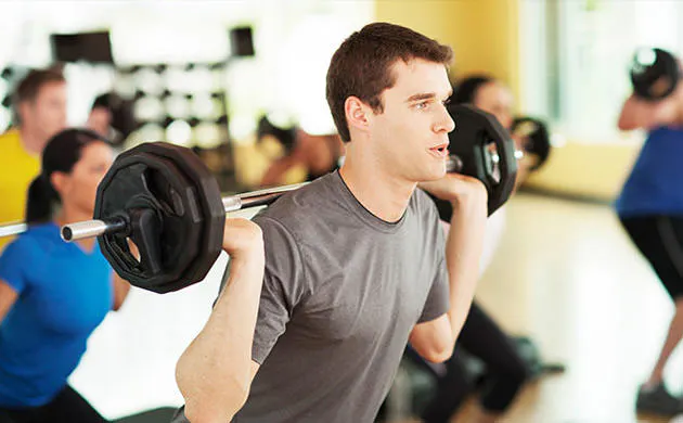 Man Rising From A Squat In A Strength Training Class