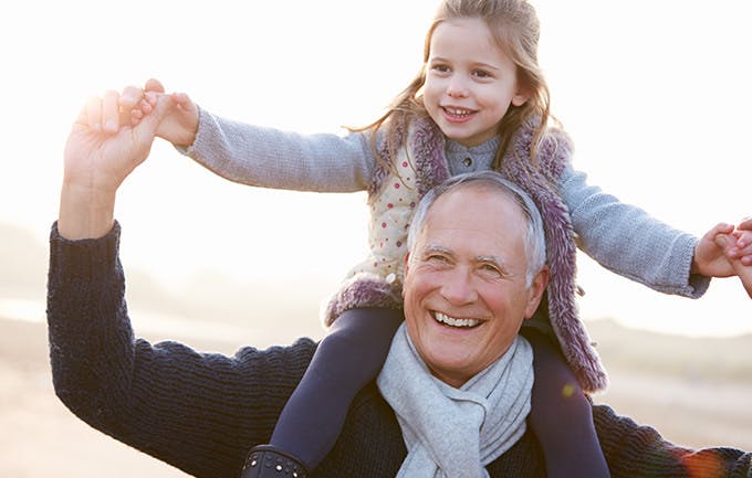 Grandfather And Granddaughter Walking On Winter Beach