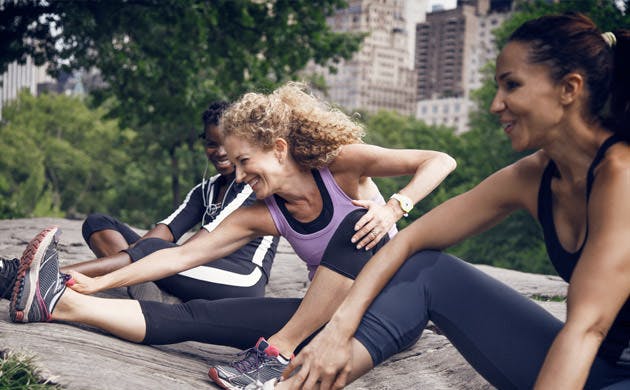 Three Friends In Exercise Gear Stretching