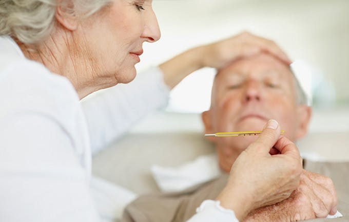Senior Woman Caring For Man With A Fever Senior Woman Caring For Man With A Fever