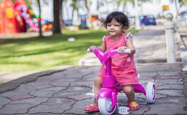 Little girl riding tricycle