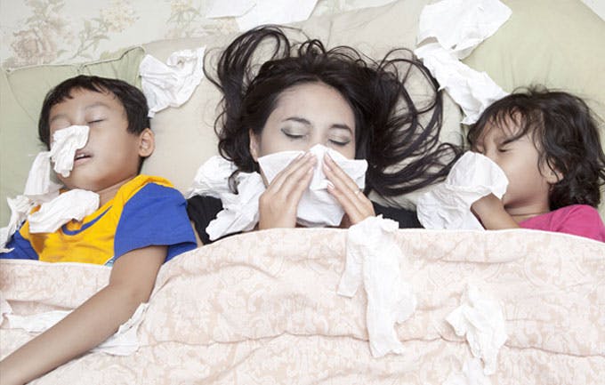 Mother, son and daughter sick in bed with flu