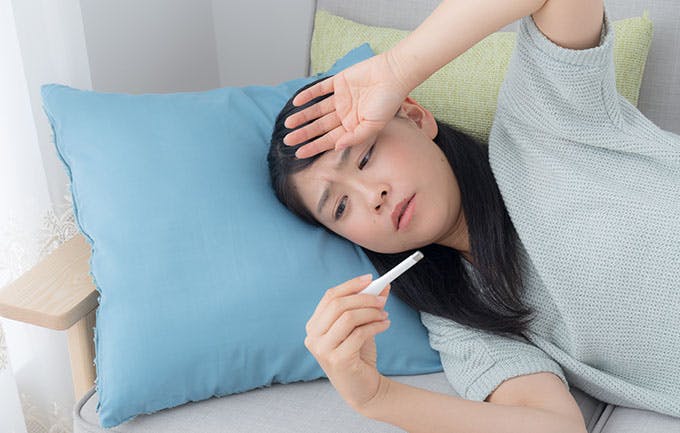 Young woman taking her temperature Young woman taking her temperature
