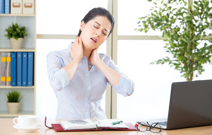 Woman in office with neck ache