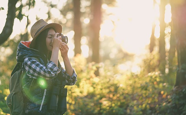 Mujer joven tomando fotografías al aire libre.